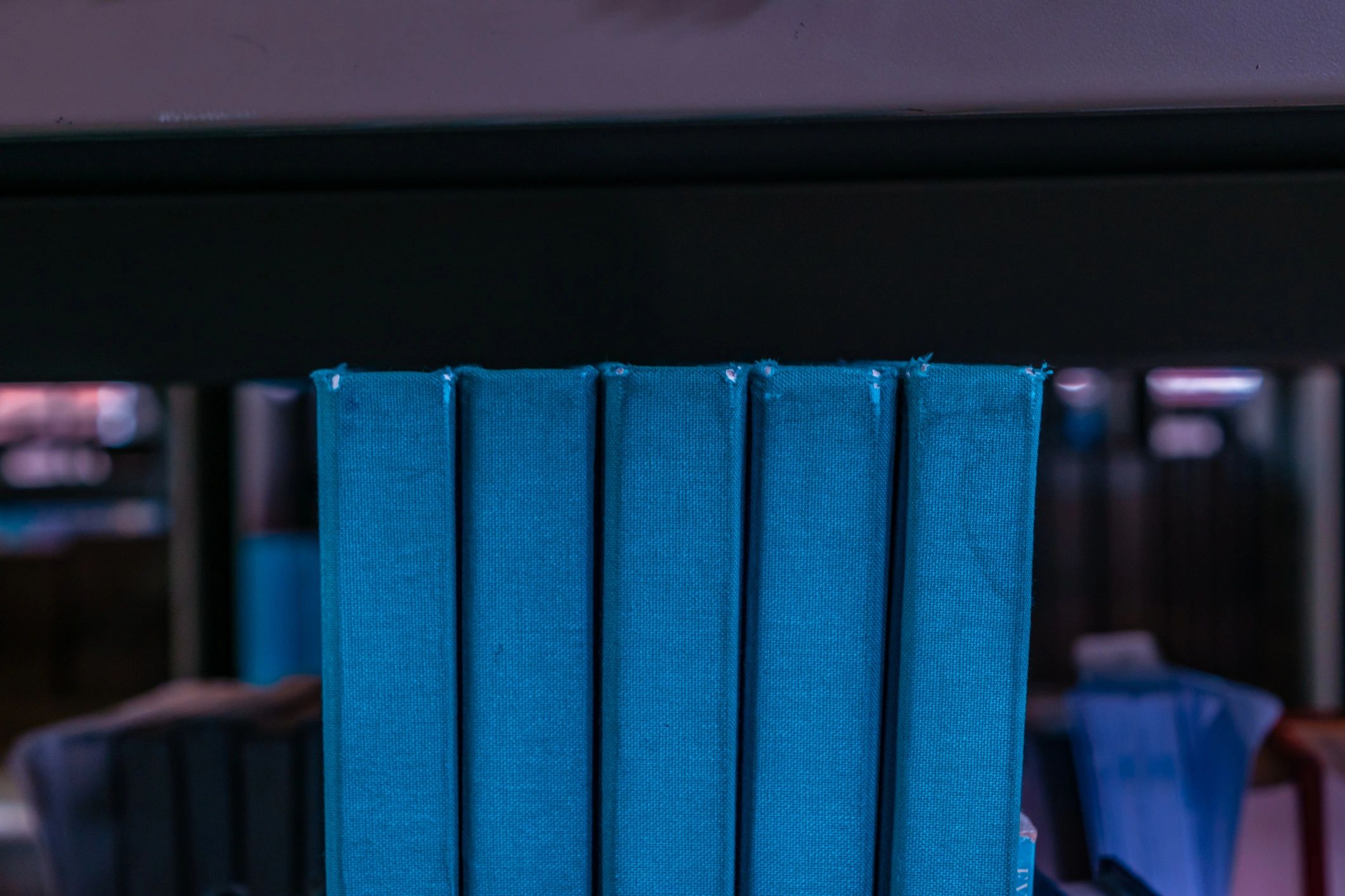 Shelves of old blue books in a grand library