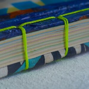 Closeup shot home bound notebook with recycled paper sheets. green woven thread