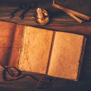 Blank antique leather-bound journal, book or diary with old books and candle