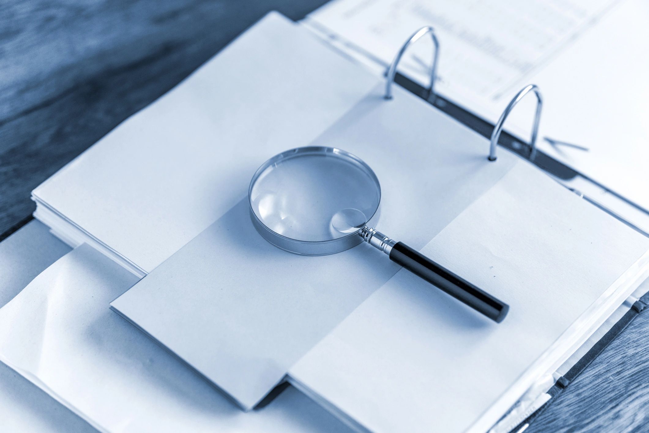 Magnifying glass resting on an open folder for printable puzzle resources