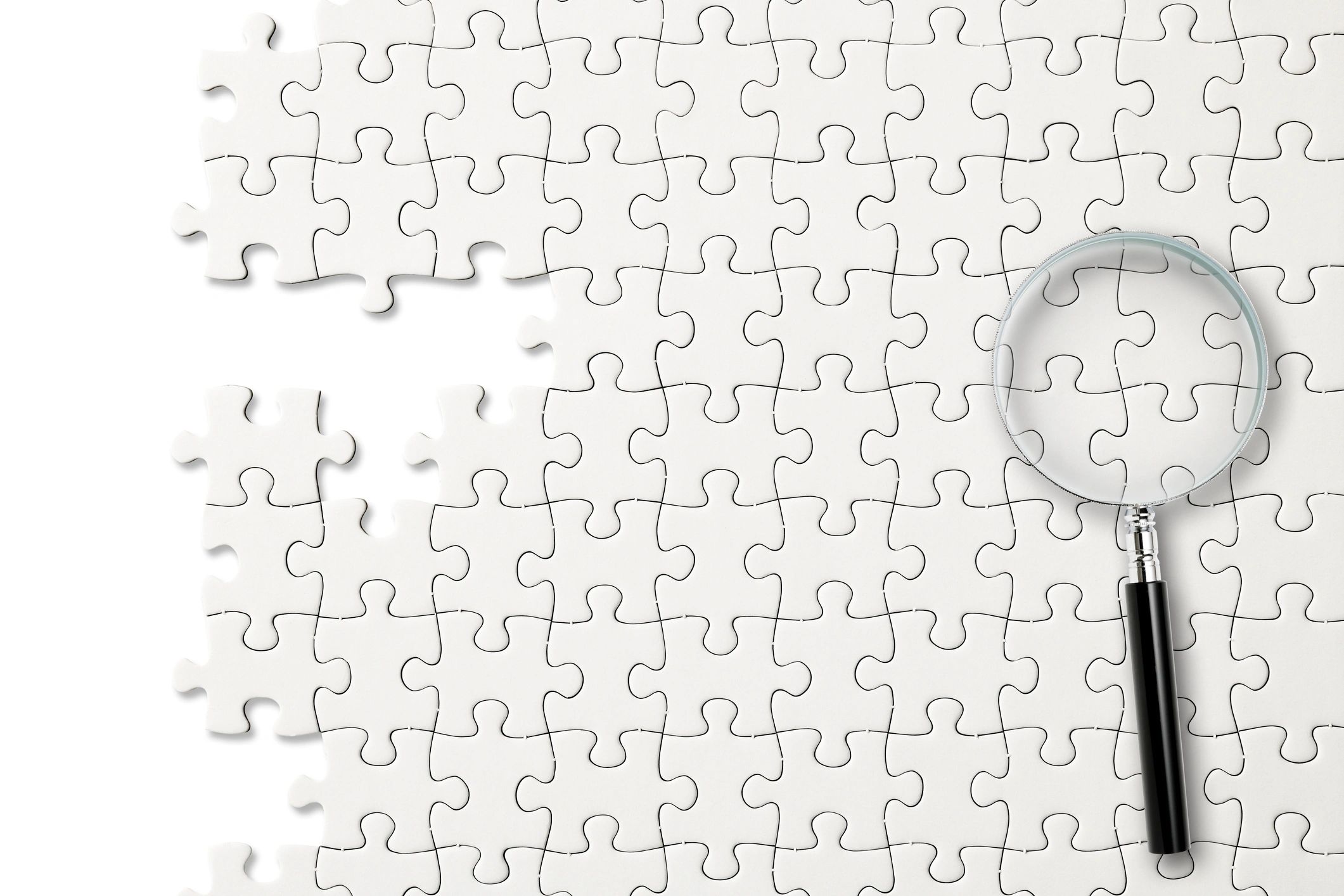 Magnifying glass over puzzle pieces