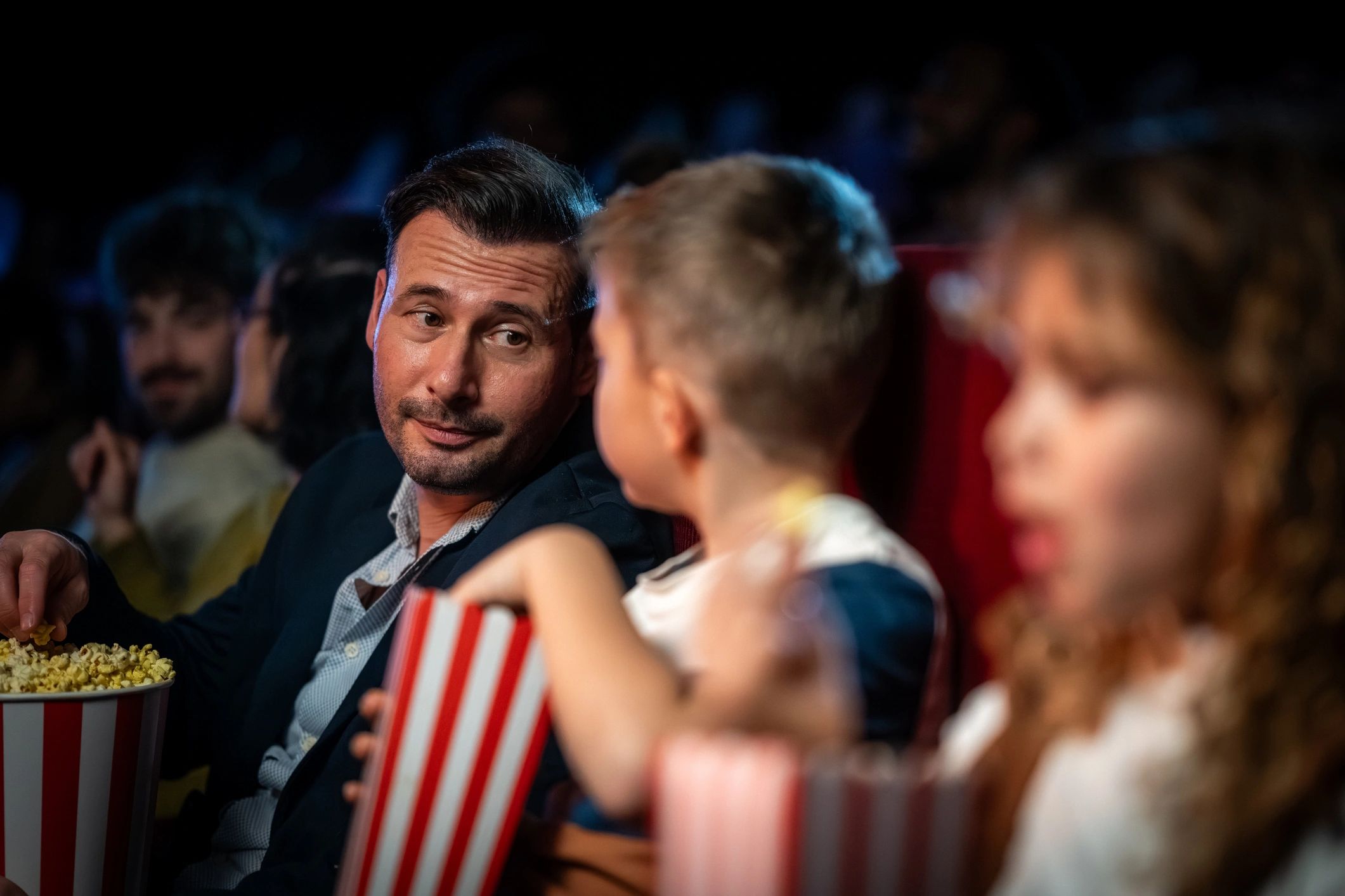 Family enjoying a movie night together in a cinema