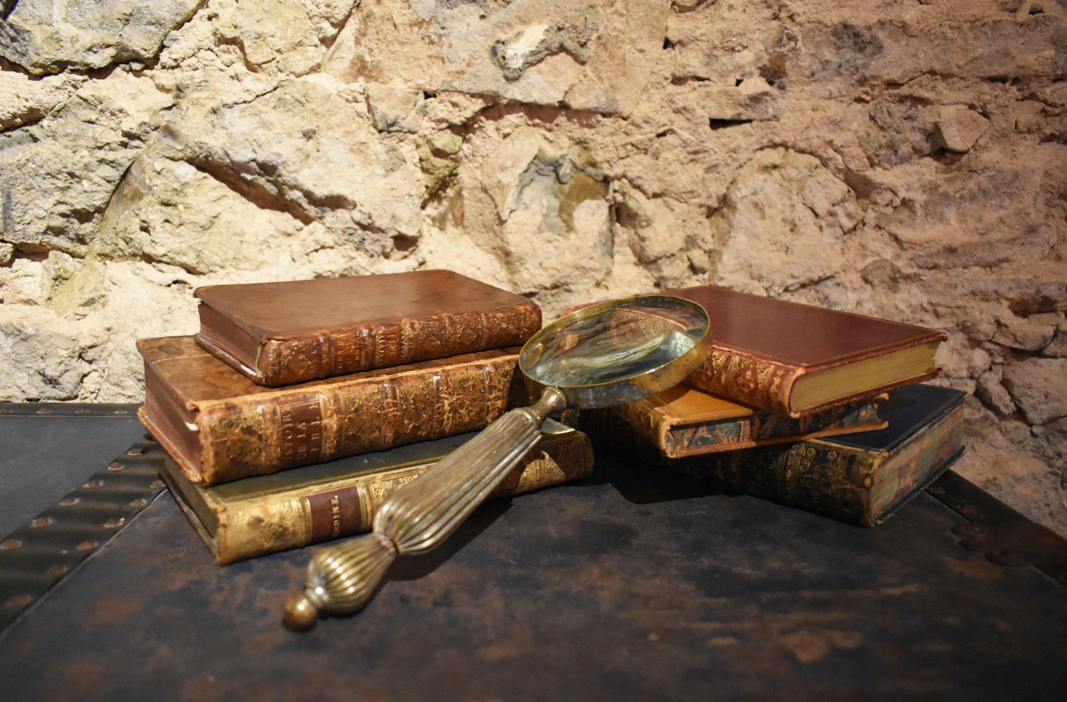 Detective-style study scene with books and magnifying glass