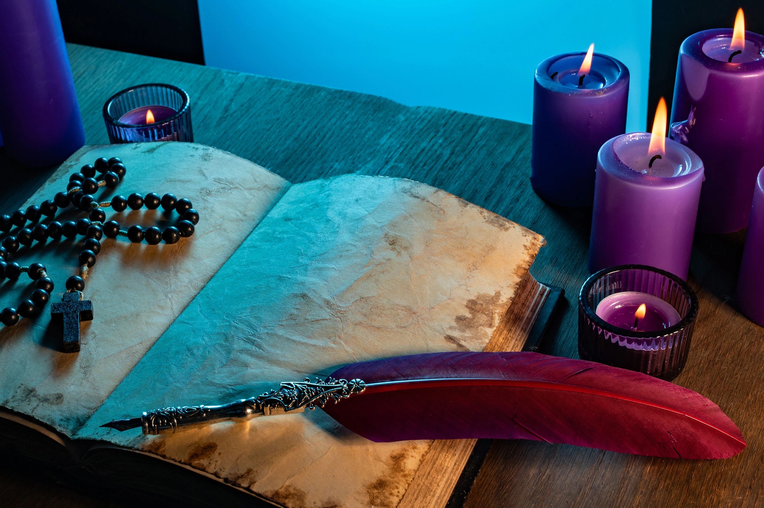 Antique open book with quill and candles on a vintage desk
