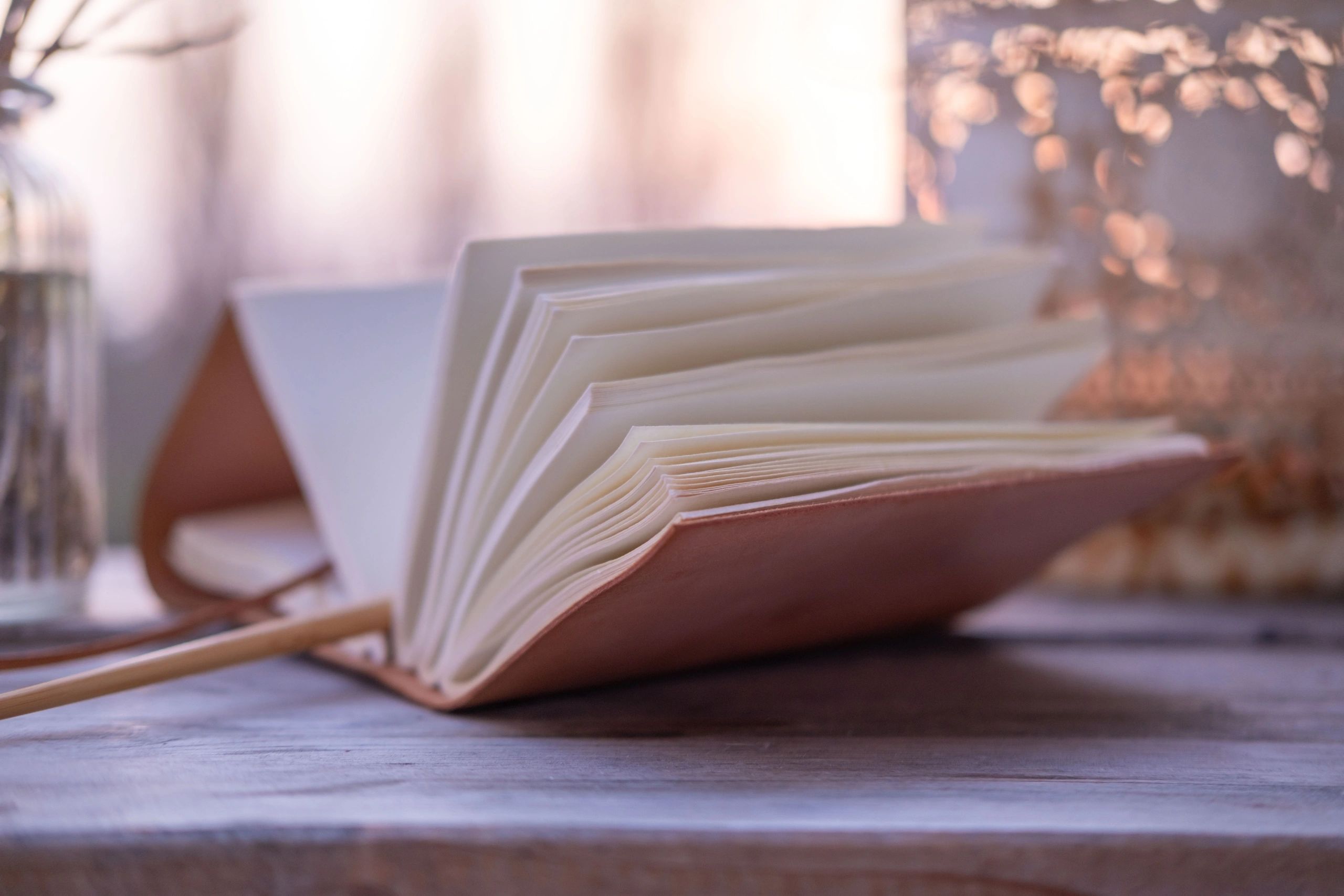 Vintage notebook and hourglass on a wooden table