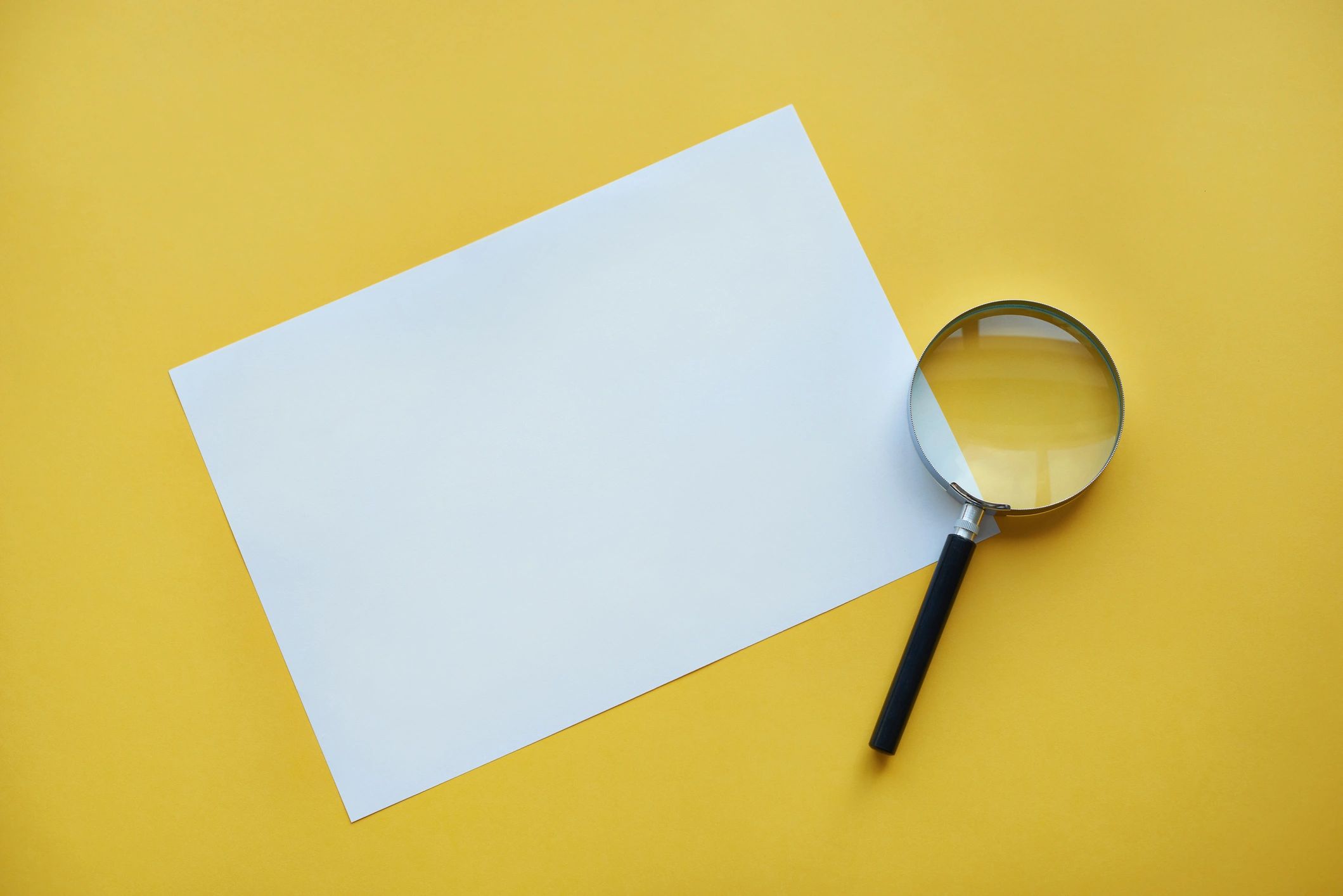 Magnifying glass over paper representing close observation and investigation