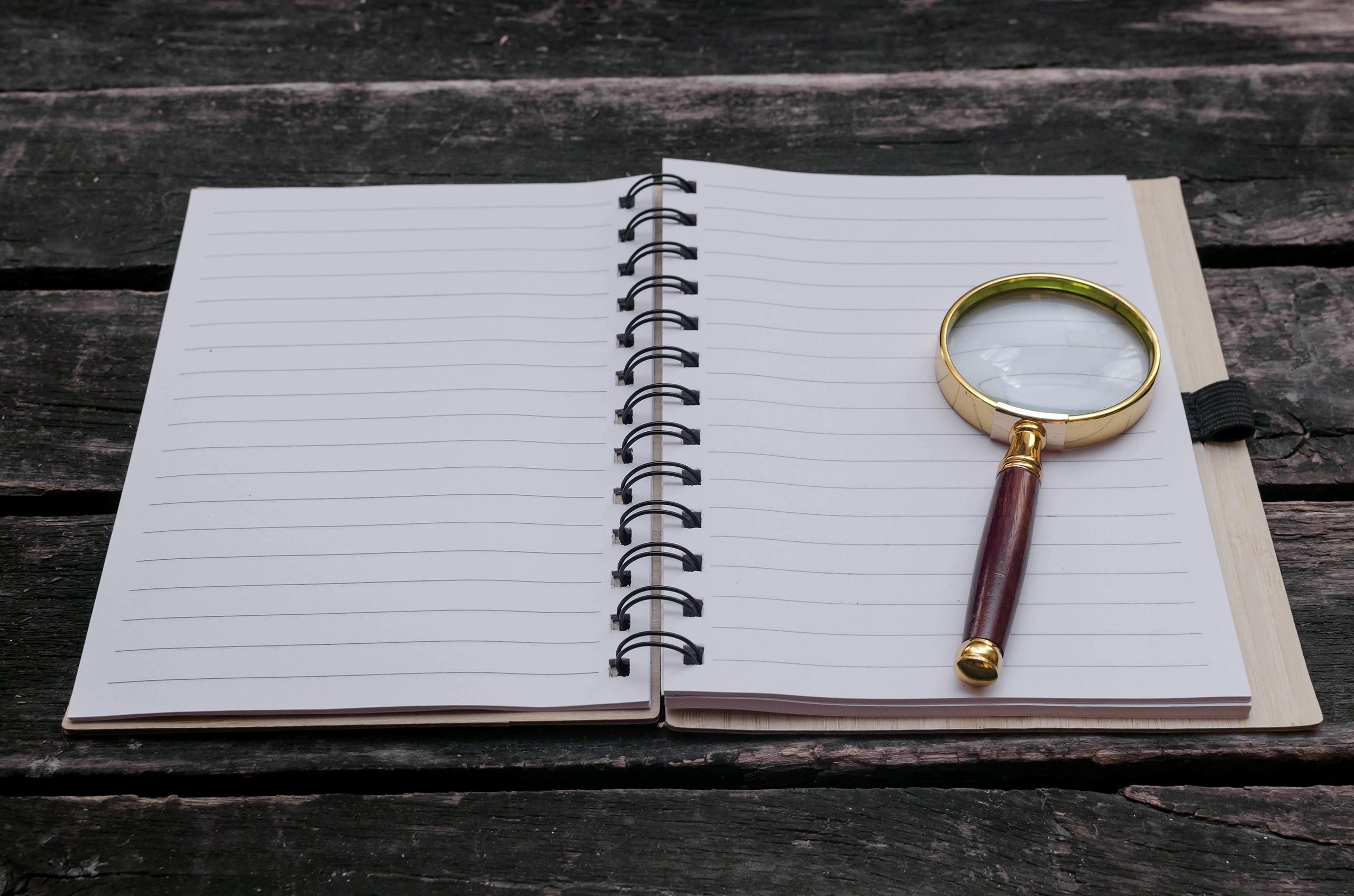 Detective notebook and magnifying glass arranged for puzzle planning